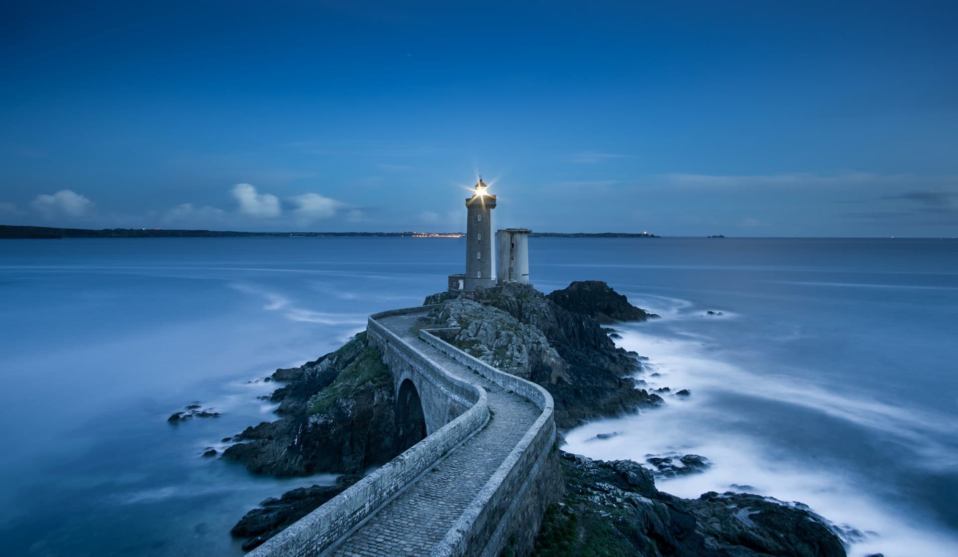 Lighthouse on rocky coastline providing guidance